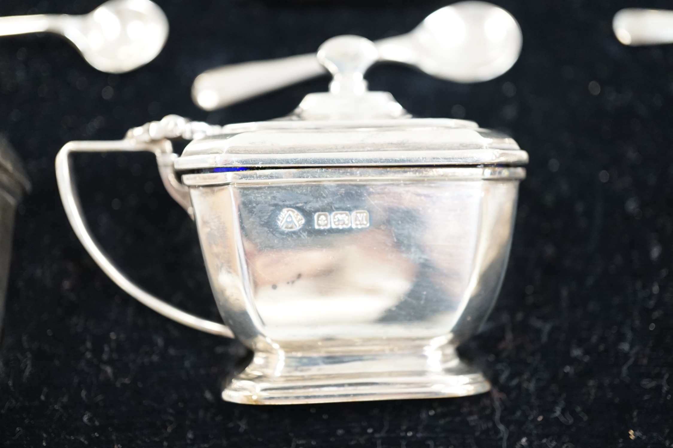 A cased Art Deco silver six piece condiment set, Adie Bros. Birmingham, 1936. with three (ex four) matching spoons, together with a silver mounted cigar cutter (a.f.).